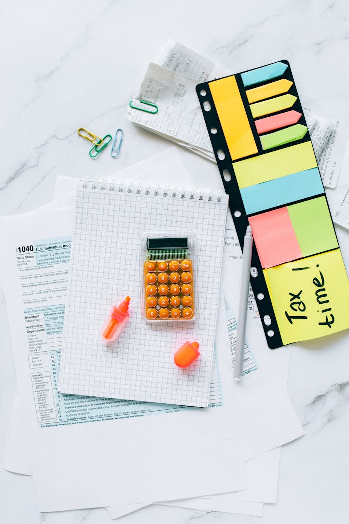 A vibrant tax preparation desk with documents, a calculator, and sticky notes for organization.